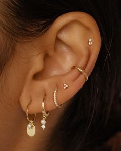 a close up of a person with ear piercings on their ears and behind the ear