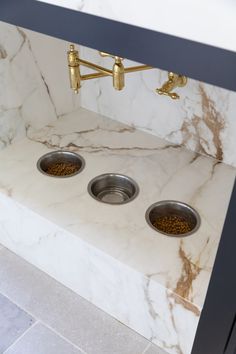 two bowls with food in them sit on a marble counter top next to a faucet