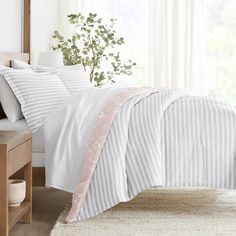 a bed with white and pink striped sheets