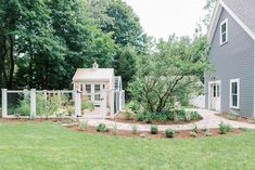 a small garden in front of a gray house