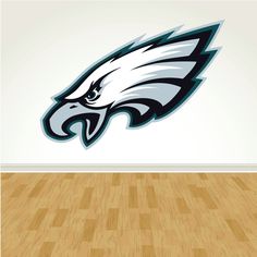 the philadelphia eagles logo is displayed on a wall in an empty room with wood floors