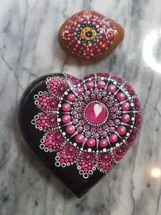 two heart shaped rocks sitting on top of a marble countertop next to each other