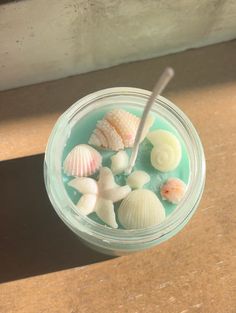 a cup filled with sea shells on top of a table