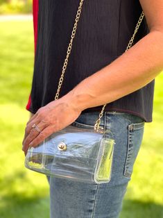 Step out in style with this glamorous, clear clutch bag, featuring a bright pearl-beaded handle, flap-over top and additional gold chain strap. The gold button closure and transparent design lets you showcase your essentials while keeping them secure. Stadium approved. Chic Clear Clutch For Party, Gold Clutch For Everyday Summer Use, Summer Gold Clutch For Everyday Use, Chic Clear Party Clutch, Gold Crossbody Shoulder Bag With Clear Strap, Chic Rectangular Shoulder Bag With Clear Strap, Chic Clear Crossbody Shoulder Bag, Trendy Gold Shoulder Bag With Clear Strap, Chic Clear Shoulder Bag With Clear Strap