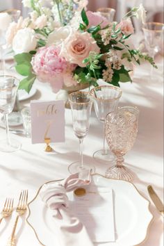 the table is set with pink and white flowers