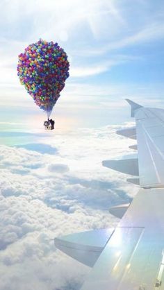 a person is flying in the sky with a heart shaped balloon attached to their back