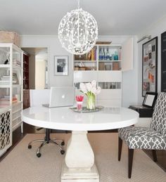 a dining room table with two chairs and a chandelier hanging from the ceiling