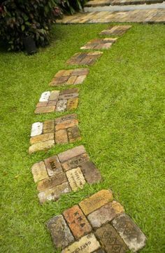 a path made out of bricks in the grass