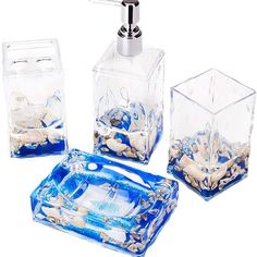 four pieces of bathroom accessories including soap dispenser, toothbrush holder and glass container