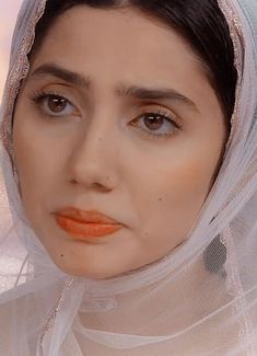 a woman wearing a veil and orange lipstick