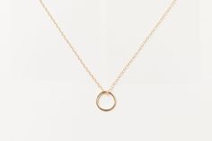 Flat lay of the Sol Circle Pendant Necklace in gold fill on a white background. Maeve Ring, New Obsession, Circle Pendant Necklace, The Minimalist, Denver Co, Recycled Gold, Negative Space, End Of Summer, Circle Pendant