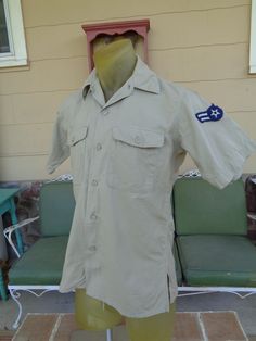 "This is a vintage military shirt from the 1950's I believe. Could be WWII era, but I am not sure. It has vintage army patches on both arms.  Measurements: laying flat 42\" chest tip of shoulder to tip of shoulder across 16\" neck to base 29.5\" Does have a rust like mark on back which is in the last photo. Nice condition with no holes or rips.  Buttons down front and has two front pockets. Please don't hesitate to ask questions. Happy collecting!" Military Style Button-up Tops, Khaki Military Style Short Sleeve Shirt, Military Style Button-up Tops With Snap Buttons, Military Button-up Shirt, Khaki Military Short Sleeve Shirt, Khaki Short Sleeve Military Shirt, Army Patches, Best Purses, Vintage Military