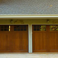 two brown garage doors in front of a house