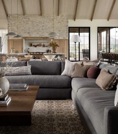 a living room filled with furniture and a stone wall in the back drop down ceiling