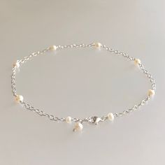 Natural freshwater pearl ankle bracelet in sterling silver This elegant anklet bracelet is designed with genuine 3.5 mm freshwater pearls, evenly spaced along sterling silver cable chain. These pearls are a high-quality, lustrous, creamy white and semi-round.  This anklet is completed with a sterling silver lobster claw clasp.  Pearls are one of June's birthstones. Details: *  length: please choose at check-out freshwater pearls:  approx. 3.5 mm  sterling silver chain and other components *  Choosing your length at checkout:  I recommend 1/2 inch larger than your actual wrist/ankle size. Bracelet/anklet is measured from end-to-end including clasp. Thanks for visiting ! Back to my shop for more jewelry options: www.etsy.com/shop/krisatdesigns Pearl Ankle Bracelet, Elegant Anklet, Bridal Anklet, Beach Wedding Jewelry, Silver Pearl Bracelet, Pearl Anklet, Silver Anklet, Vanilla Girl, Ankle Chain