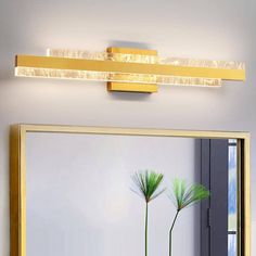 a bathroom with a mirror and two plants on the counter