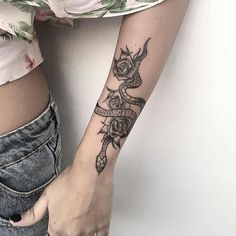 a woman's arm with a tattoo on it and a rose in the middle