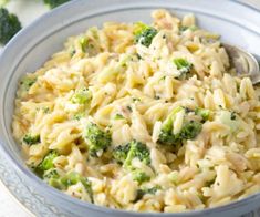 a bowl filled with pasta and broccoli on top of a table