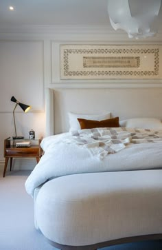 a bedroom with a large bed and white walls