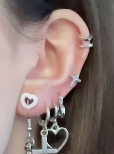 a close up of a person's ear with two different earrings attached to it