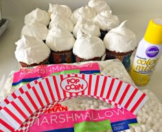 cupcakes and marshmallows are on a plate next to some candy