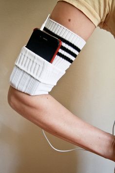 the arm is wrapped in white and black strips with a cell phone attached to it