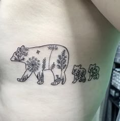 a bear and cub tattoo on the side of a woman's stomach, with trees