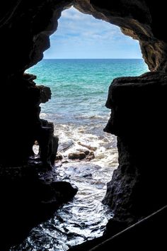 an open cave with the ocean in the background