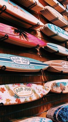 many surfboards are hanging up on the wall