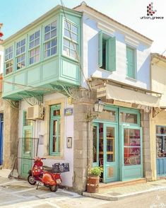 a scooter parked in front of a building with shutters on the windows