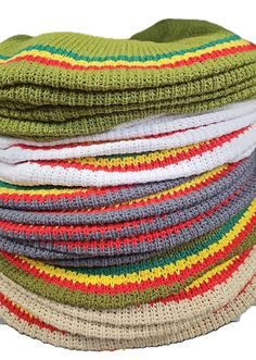 stack of multicolored knitted beanies on white background