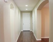 an empty hallway with hard wood floors and white walls