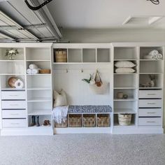 a room with white shelving and baskets on the floor