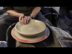 a woman sitting in a wheel making a bowl on top of a potter's wheel