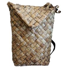 a brown woven bag sitting on top of a white background