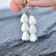 Beautiful hand carved Mother of Pearl Pikake bead earrings. These Pikake are not plastic, they are real carved mother of pearl. Your choice of sterling silver or gold fill - they will not tarnish and can even get wet. These Pikake earrings feature three small Pikake clustered together and go beautifully with any outfit. Click here to see the matching necklace: https://www.etsy.com/listing/1015053440/triple-pikake-cluster-necklace Each Pikake is hand carved and may vary slightly one from the next Hawaiian Pearl Necklace, White Teardrop Flower Earrings For Gift, Pearl White Drop Flower Earrings For Gifts, White Teardrop Jewelry With Flower Charm, White Pearl Earrings With Flower Charm For Gift, Handmade Drop Earrings For Bridesmaids, Handmade Drop Earrings For Bridesmaid Gift, Flower Shape Pearl Drop Jewelry For Gifts, Flower Shaped Pearl Drop Jewelry For Gifts