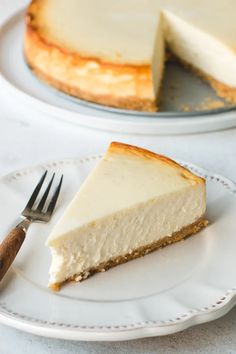 a slice of cheesecake on a plate with a knife and fork next to it