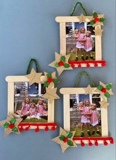 three wooden frames with christmas decorations hanging from the sides, and two pictures on them