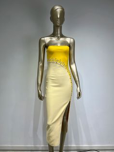 a mannequin wearing a yellow and white dress