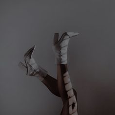 a woman's legs with white socks and high heeled shoes in the air