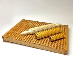 a wooden cutting board with two corn on it