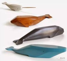 three different types of wooden spoons on a white surface, one is shaped like a whale and the other is shaped like a bird