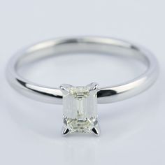 a white gold ring with an emerald cut diamond