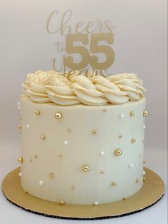 55th birthday cake with custom gold topper. Cream colored buttercream with piped ring on top with gold glitter and gold decorations 50th Birthday Cake White And Gold, White Golden Cake Design, Vintage 60th Birthday Cake, Women’s Cake Ideas, 60th Buttercream Birthday Cake, Simple White Birthday Cake Design, White And Gold Cake Graduation, Gold And Cream Cake Ideas, Small 60th Birthday Cake