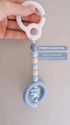 a hand holding a blue and white baby pacifier