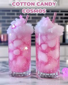 two glasses with cotton candy in them sitting on a counter top next to a pink ball