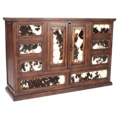 an old wooden sideboard with cow hides on the top and bottom paneling