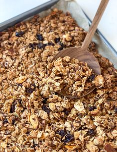 a pan filled with granola and a wooden spoon