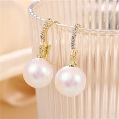 These delicate 18k gold-palted earrings feature dangling pearls and cubic zirconia embellishments. 0.47" W x 1.14" L 18k gold-palted copper / pearl / cubic zirconia Copper Pearl, Cubic Zirconia, Embellishments, 18k Gold, Copper, Drop Earrings, Gold