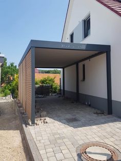 an outdoor covered patio area in the middle of a yard with brick pavers and stone walkway